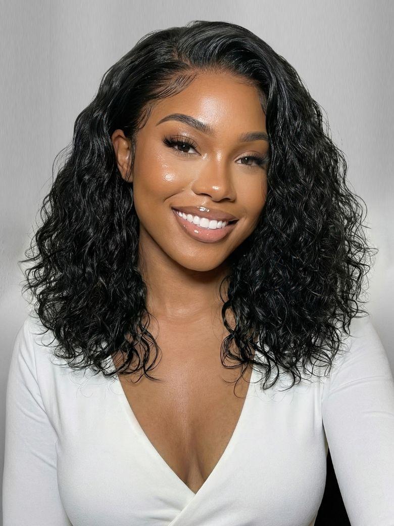Smiling woman wearing a black wavy shoulder-length wig with a natural side-parted hairline.